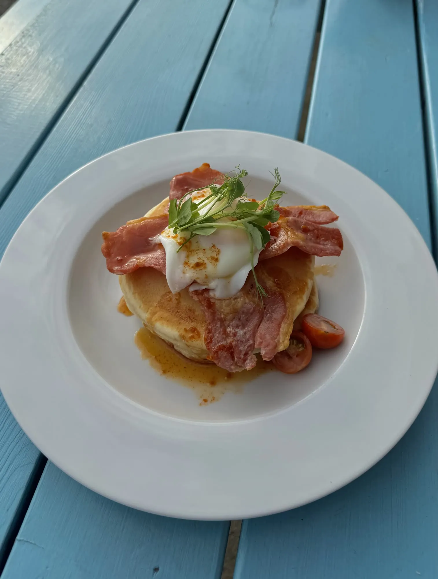 Buttermilk pancakes with crispy bacon, a poached egg and caramel chilli drizzle