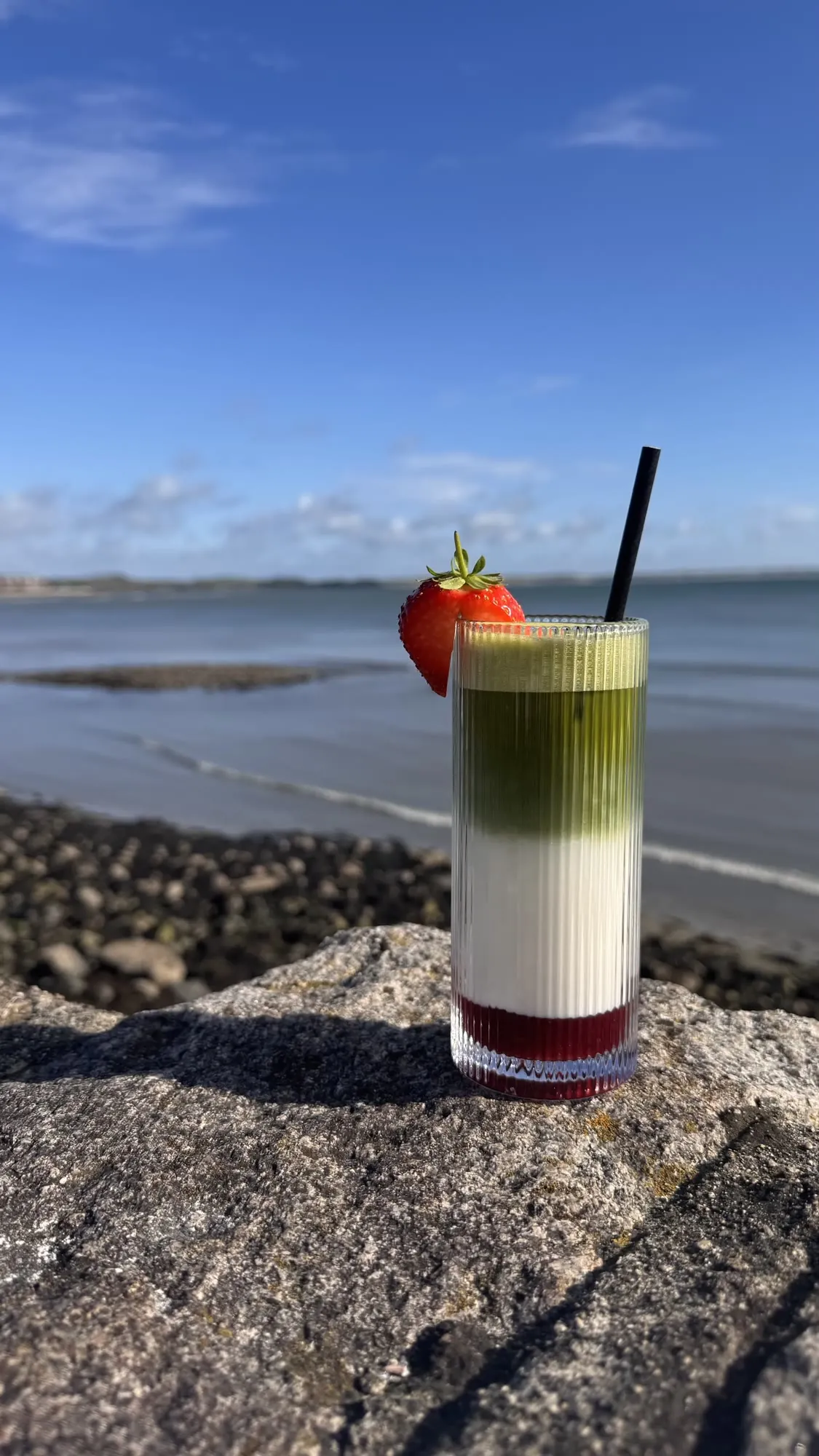 Iced strawberry matcha on the sea wall in Newcastle