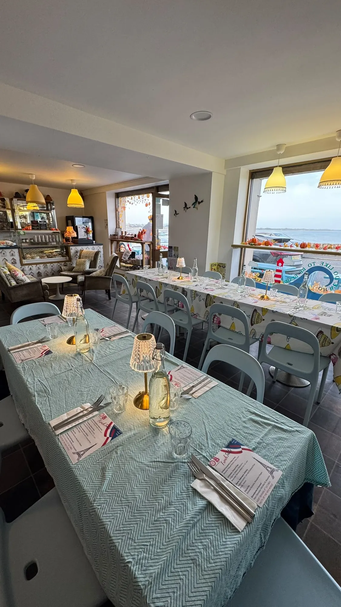 The Olive Bizarre dining room with tables set and a view of the sea