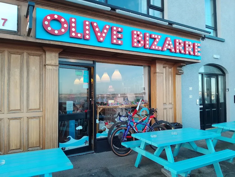 The Olive Bizarre shop front on South Promenade, with blue picnic benches outside