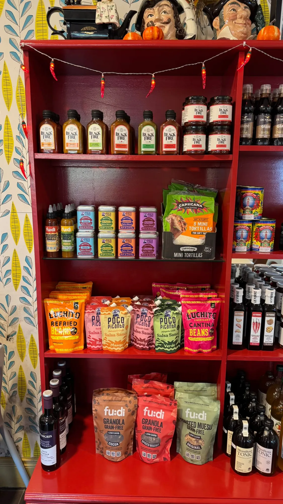 Red shelves of sauces, snacks and granola in the Olive Bizarre shop